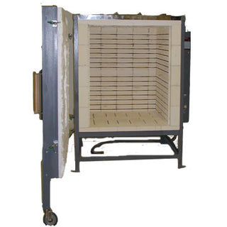 Olympic FL-36 front loading electric kiln used for ceramics, shown during cleaning with a view of the kiln's front door and control panel.
