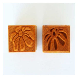White MKM SSM 102 medium square stamp with coneflower design, used as a texture tool for pottery and clay surfaces.