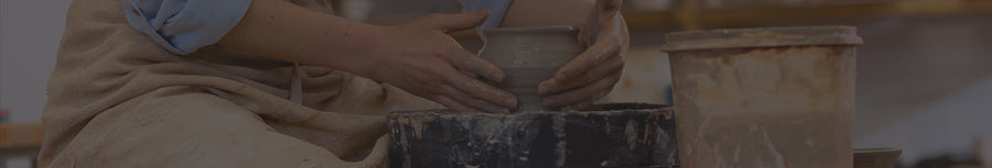 Hands shaping a clay pot on a pottery wheel